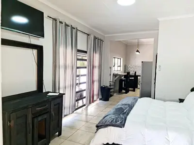a bedroom with a white bed and a television at B&B Accommodation 109 Bezuidenhout in Mokopane