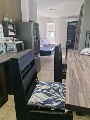 a room with a kitchen with a table and a room with a bed at B&B Accommodation 109 Bezuidenhout in Mokopane