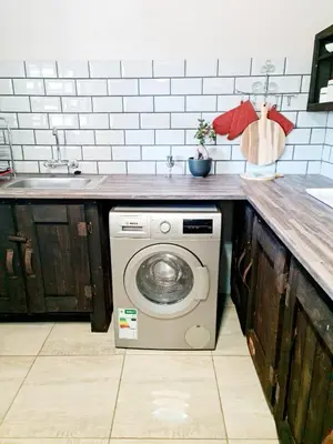 a kitchen with a washing machine under a counter at B&B Accommodation 109 Bezuidenhout in Mokopane