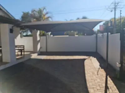 a backyard with a white fence and a table at B&B Accommodation 109 Bezuidenhout in Mokopane