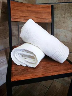 a rolled up white towel sitting on a chair at African Hoopoe Inn in Polokwane