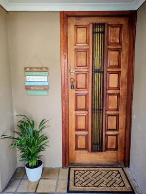 a wooden door with a plant in front of it at African Hoopoe Inn in Polokwane