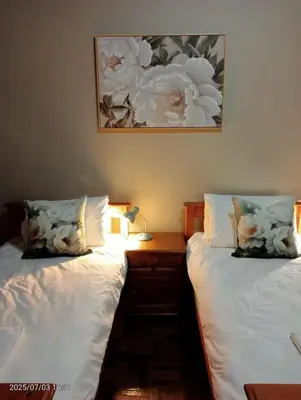 two beds sitting next to each other in a bedroom at Ode to Tranquility House - Pax 6 in Pretoria