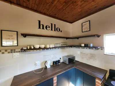a kitchen with a counter with a hello sign on the wall at Ode to Tranquility House - Pax 6 in Pretoria