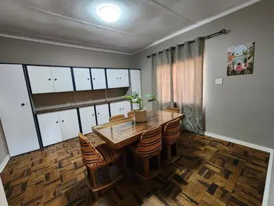 a dining room with a wooden table and chairs at Ode to Tranquility House - Pax 6 in Pretoria