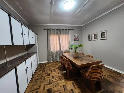 a dining room with a wooden table and chairs at Ode to Tranquility House - Pax 6 in Pretoria