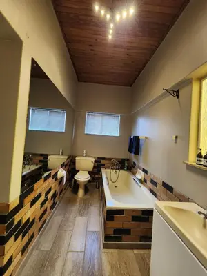 a bathroom with a tub and a toilet and a sink at Ode to Tranquility House - Pax 6 in Pretoria
