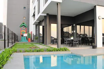a swimming pool in front of a building at Golden Sunset Skyline View in Midrand