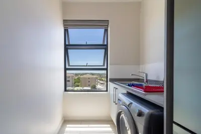 a small kitchen with a sink and a window at Golden Sunset Skyline View in Midrand