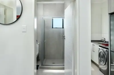 a bathroom with a shower with a glass door at Golden Sunset Skyline View in Midrand