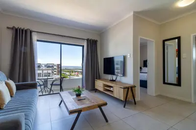 a living room with a couch and a tv at Golden Sunset Skyline View in Midrand
