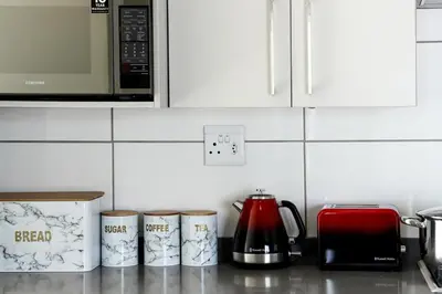 a kitchen counter with three coffee cups and a microwave at Golden Sunset Skyline View in Midrand