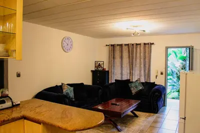 a living room with two couches and a table at LOSKOP HOSPITALITY at TOLEDO APARTMENTS in Pretoria
