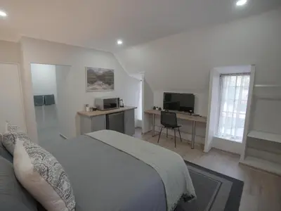 a bedroom with a bed and a desk and a television at Insolam Accommodation in Mokopane