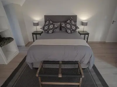 a bedroom with a large bed with two tables at Insolam Accommodation in Mokopane