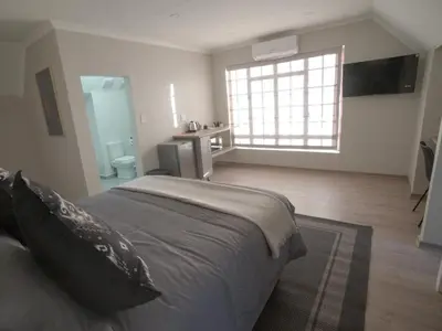 a bedroom with a large bed and a bathroom at Insolam Accommodation in Mokopane