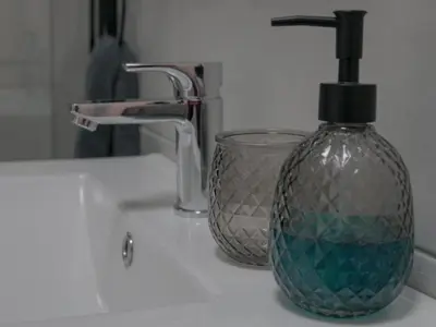 a glass bottle sitting on a sink next to a faucet at Insolam Accommodation in Mokopane