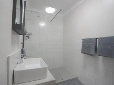 a white bathroom with a sink and a shower at Insolam Accommodation in Mokopane