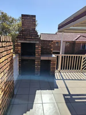 an outdoor brick fireplace on a patio of a house at Centurion villa in Centurion