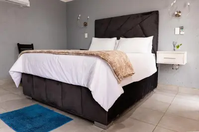 a bedroom with a large bed with white sheets and pillows at Empfunweni Guesthouse in Matsulu