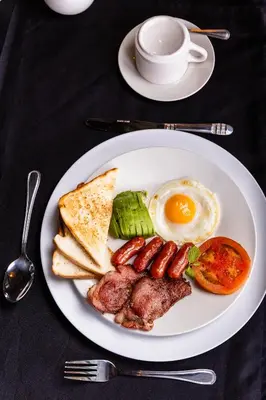 a plate of breakfast food with eggs sausage and toast at Empfunweni Guesthouse in Matsulu