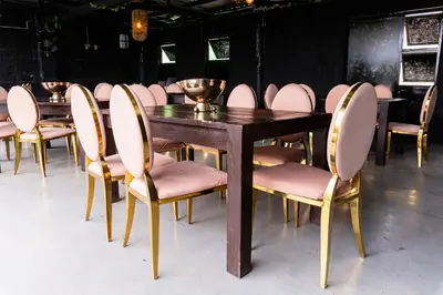 a wooden table and chairs with pink chairs around it at Empfunweni Guesthouse in Matsulu