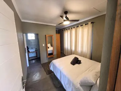 a bedroom with a bed with a black object on it at Klugro Cottage in Nelspruit