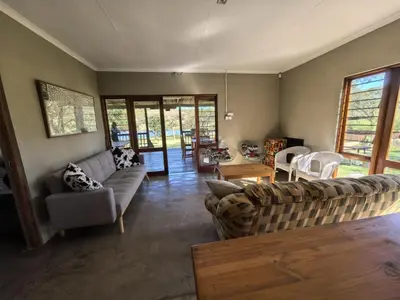 a living room with a couch and a table at Klugro Cottage in Nelspruit