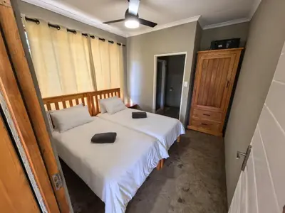 a bedroom with a bed with two pillows on it at Klugro Cottage in Nelspruit