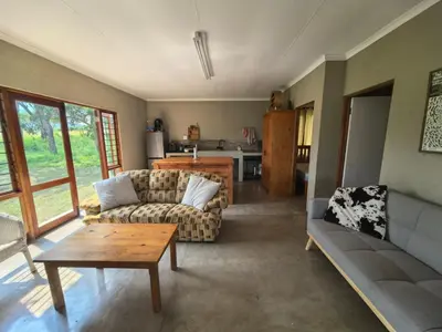 a living room with a couch and a table at Klugro Cottage in Nelspruit