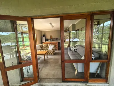 a living room with sliding glass doors at Klugro Cottage in Nelspruit