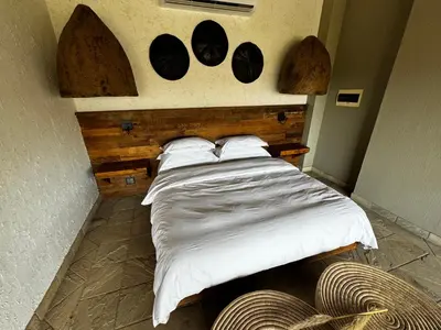 a bed with white sheets and pillows in a room at RoiSan Private Game Lodge in Rooiberg