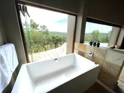 a white bath tub in a bathroom with a window at RoiSan Private Game Lodge in Rooiberg