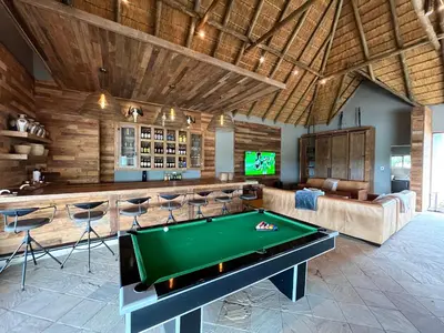 a pool table in a room with a bar at RoiSan Private Game Lodge in Rooiberg