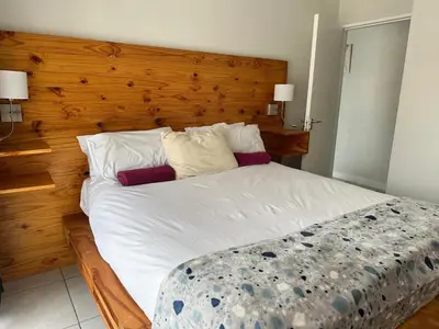 a bedroom with a large bed with a wooden headboard at regal retreat in the blyde in Pretoria