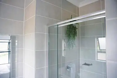 a shower with a glass door in a bathroom at regal retreat in the blyde in Pretoria