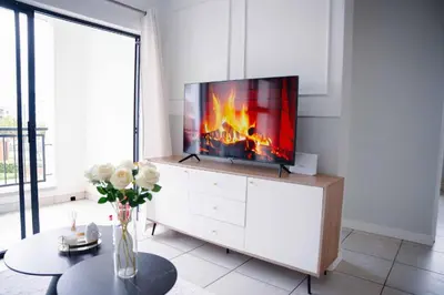 a living room with a tv on top of a dresser at regal retreat in the blyde in Pretoria