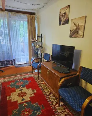 a living room with a television and a desk and chairs at Cottage of the Grumpy Old Man, no loadshedding in Pretoria