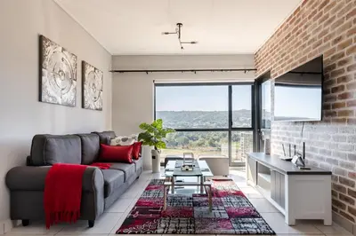 a living room with a couch and a brick wall at Lowveld Getaway in Nelspruit