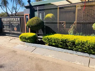 a bush sitting on a bench in front of a fence at Urban Space Lodge in Pretoria