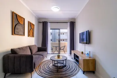 a living room with a couch and a table at First Floor 2 Beds Premium Suite in Midrand