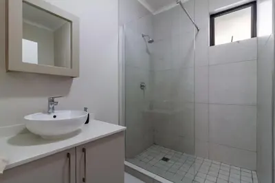 a white bathroom with a sink and a shower at First Floor 2 Beds Premium Suite in Midrand