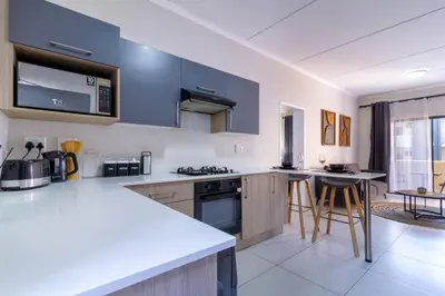 a kitchen with blue cabinets and a counter top at First Floor 2 Beds Premium Suite in Midrand