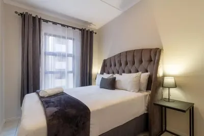 a bedroom with a large bed with a large window at First Floor 2 Beds Premium Suite in Midrand