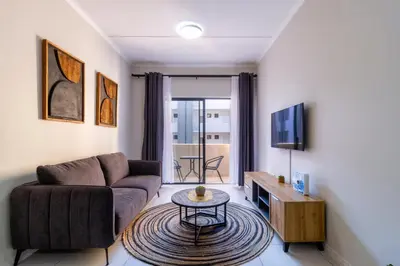 a living room with a couch and a table at First Floor 2 Beds Premium Suite in Midrand