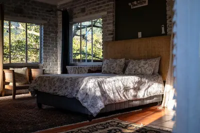 a bedroom with a bed and a brick wall at 59 Kiepersol in Kampersrus AH