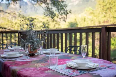 a table with plates and wine glasses on a deck at 59 Kiepersol in Kampersrus AH