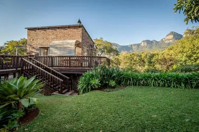 a brick house with a wooden deck and a yard at 59 Kiepersol in Kampersrus AH