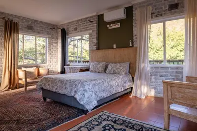 a bedroom with a bed in a room with windows at 59 Kiepersol in Kampersrus AH