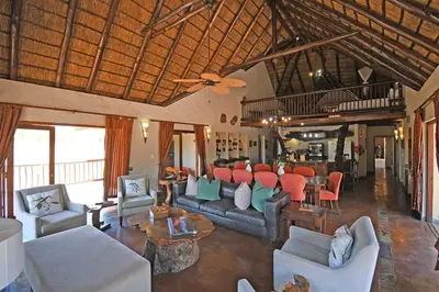 a living room with couches and chairs and a table at Damani Lodge at Zebula Golf Estate and Spa in Warmbaths